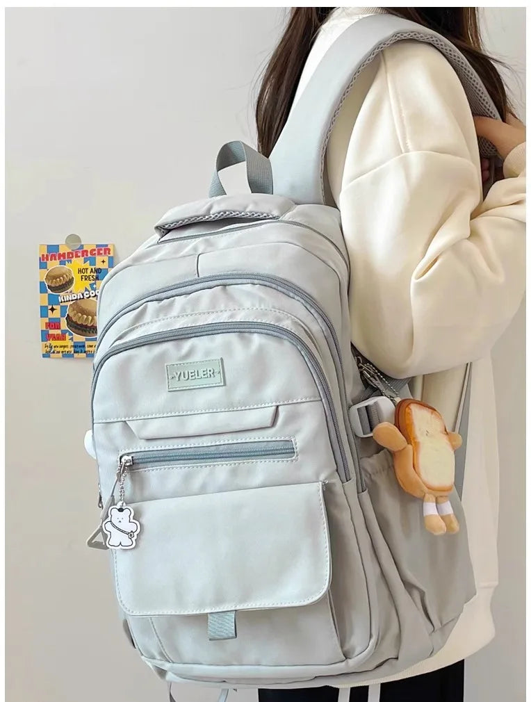 Sac à dos en nylon gris clair, style japonais, avec porte-clés et grande capacité, porté par une étudiante.