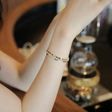 Pulsera con dijes de oro brillante