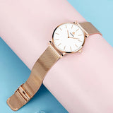 Montre femme WWOOR or rose avec cadran blanc, vue de côté élégante