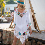 Femme de dos portant une tunique de plage bohème blanche en crochet avec franges colorées