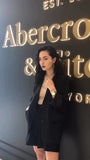 Femme portant une montre Hannah Martin dorée avec un tailleur noir, style élégant et professionnel