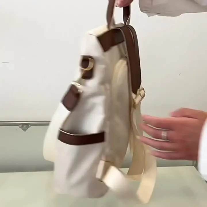 Détail du sac à dos antivol en nylon avec pompon, couleur beige et marron