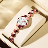 Montre femme bracelet doré rose et blanc sur présentoir, pour un style raffiné