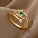 Bague ajustable œil grec doré avec zircons bleus et blancs sur fond beige