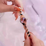 Montre femme élégante dorée avec bracelet en maillons géométriques, tenue par des mains