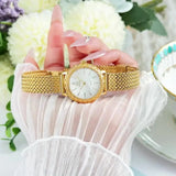 Montre femme OLEVS dorée et cadran blanc sur poignet