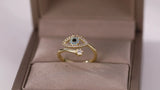 Bague ajustable œil protecteur doré avec zircons bleus et blancs sur fond beige