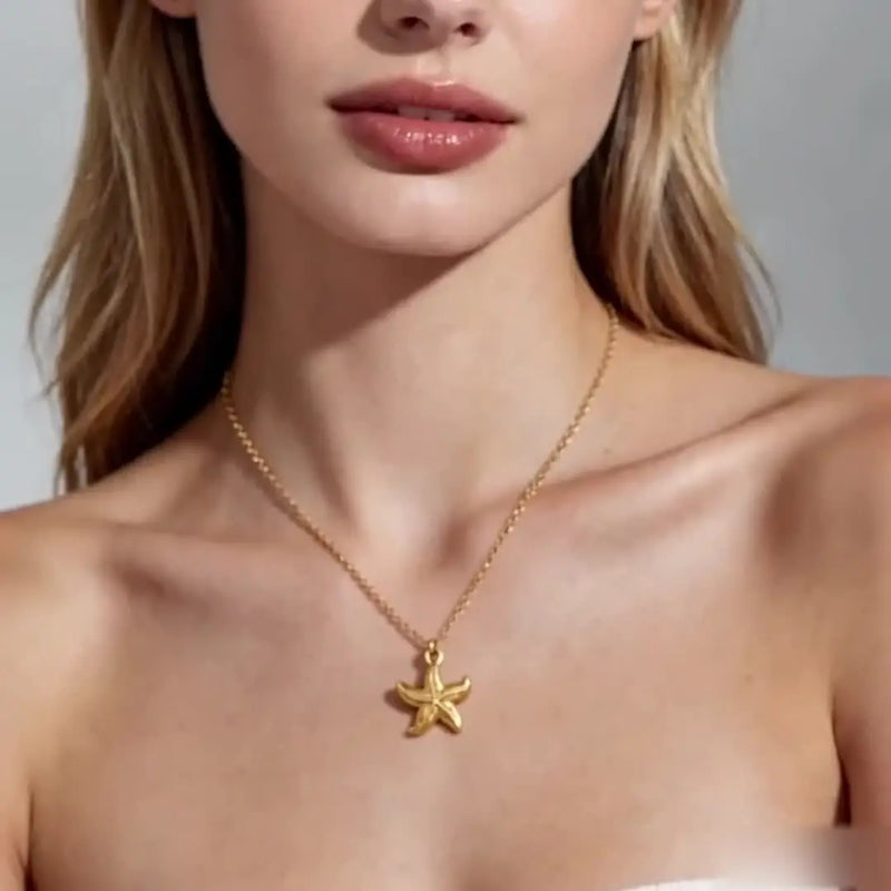 Collier doré étoile de mer sur décolleté féminin