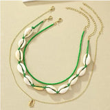 Ensemble de deux colliers fantaisie, un ras-du-cou perles vertes et coquillages, l'autre chaîne fine avec pendentif coquillage doré