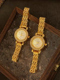 Deux montres quartz dorées pour femme sur une surface texturée foncée