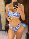 Femme en bikini brésilien motif faïence bleue et blanche, posant devant un miroir, reflet
