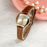 Montre femme Naidu portée au poignet, bracelet en cuir marron, style bohème