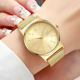 Montre dorée Emakujitia au poignet d'une femme, manucure chic