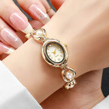 Montre bracelet dorée à perles et strass portée au poignet d'une femme