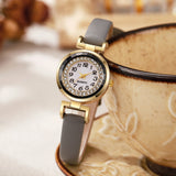 Gros plan du bracelet en cuir d'une montre femme bohème chic avec détails dorés