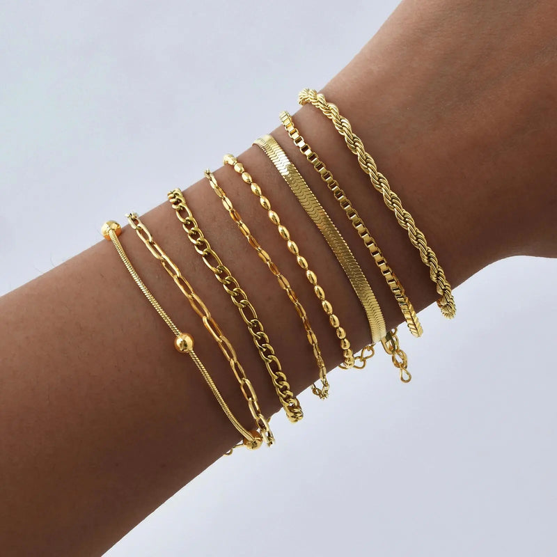 Collection de bracelets chaîne dorés en acier inoxydable portés sur un poignet