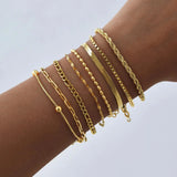 Collection de bracelets chaîne dorés en acier inoxydable portés sur un poignet