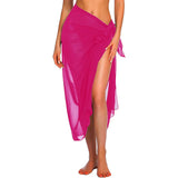 Femme portant un sarong de plage rose fuchsia transparent noué sur le côté