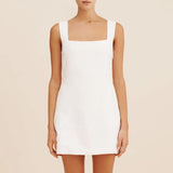 Femme portant une robe courte bohème blanche en lin et coton avec col carré