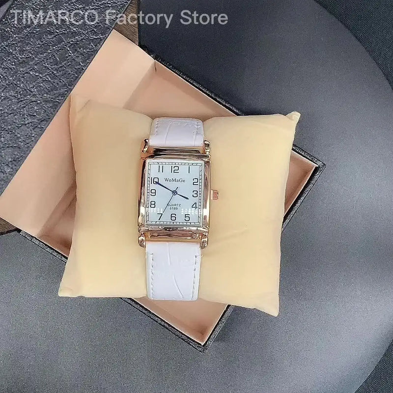 Montre femme cadran carré blanc et bracelet en cuir blanc sur coussin beige