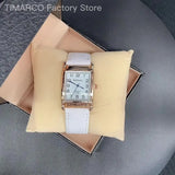Montre femme cadran carré blanc et bracelet en cuir blanc sur coussin beige