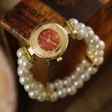 Montre fantaisie pour femme, bracelet perles, cadran rouge vif et détails dorés