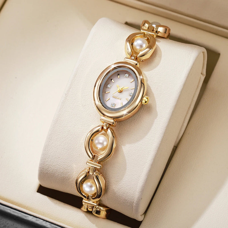 Montre élégante dorée et perles sur présentoir beige