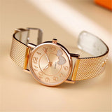 Montre femme élégante dorée rose avec cœurs scintillants et bracelet maille milanaise vue de côté