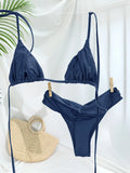 Modèle portant le bikini triangle plissé noir en bord de mer