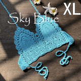 Bralette crochet bohème couleur bleu ciel taille XL sur fond bois, avec étoile de mer et fleur de frangipanier