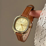 Montre carrée vintage femme avec bracelet en cuir bordeaux et cadran doré, vue de face