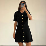 Robe courte noire tricotée avec boutons dorés, style épuré et moderne pour un look sophistiqué.