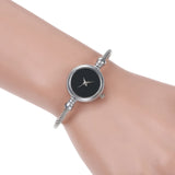 Montre bracelet argentée avec cadran noir portée au poignet