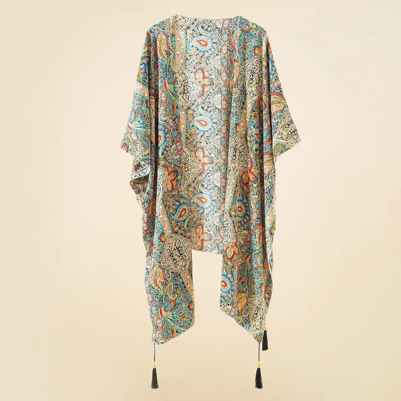 Kimono de plage bohème floral avec glands, suspendu sur un fond neutre