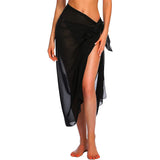 Gros plan d'une femme portant un sarong noir transparent à la plage