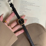 Montre carrée vintage femme avec bracelet en cuir noir et cadran doré, vue de face