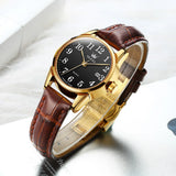 Montre OLEVS classique pour femme avec cadran noir et bracelet en cuir marron, vue de côté