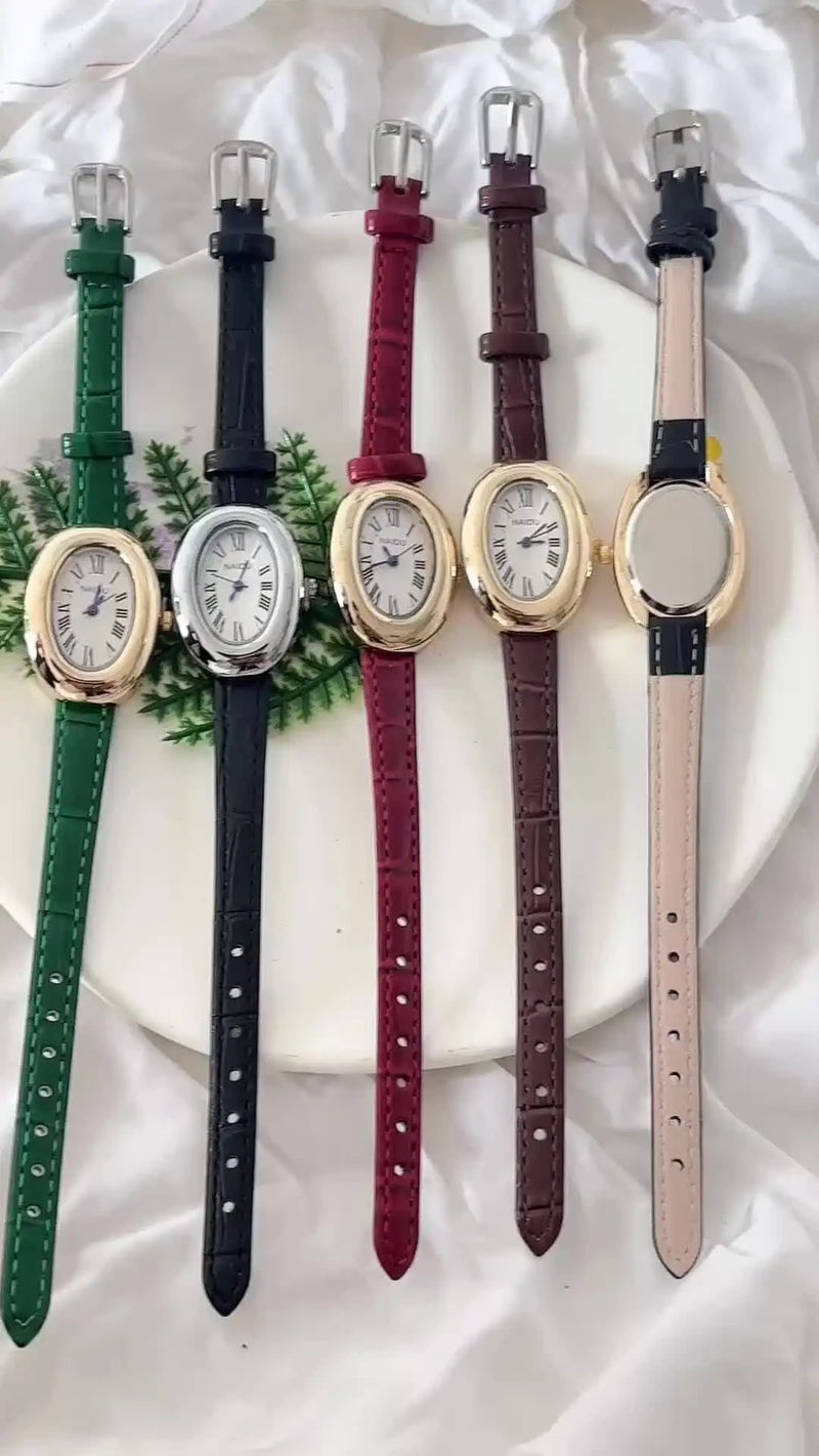 Cinq montres ovales vintage avec différents bracelets en cuir sur une assiette blanche
