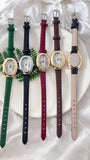 Cinq montres ovales vintage avec différents bracelets en cuir sur une assiette blanche