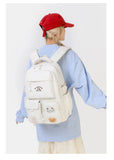Sac à dos femme en nylon blanc avec design trendy, porté par une jeune femme en tenue décontractée.