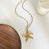 Collier doré avec pendentif coquillage et perle