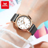 Montre femme maille milanaise noire et rose doré portée au poignet