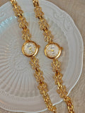 Deux montres bracelet papillons dorés avec strass sur fond clair
