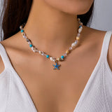 Collier perles irrégulières blanches avec pendentif étoile de mer dorée, gros plan sur le bijou