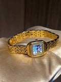 Montre femme dorée élégante avec cadran nacre et strass, style rétro classique