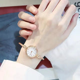 Montre bracelet noire avec cadran noir à chiffres romains portée au poignet