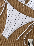Maillot de bain jaune à pois noirs, présenté sur fond clair