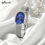 Montre femme cadran ovale bleu avec bracelet milanais argenté sur tissu blanc