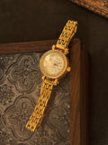Montre quartz dorée élégante pour femme avec cadran nacre et strass en gros plan