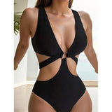 Femme portant un maillot de bain une pièce noir évidé avec décolleté plongeant et anneau doré
